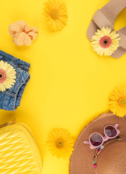 Summer fashion outfit frame background with straw hat, shoes, sunglasses, handbag, flowers on yellow - Photo, Image