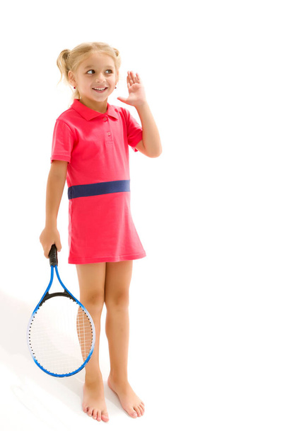 A little girl holds a tennis racket in her hands. Game, sports concept. - Valokuva, kuva