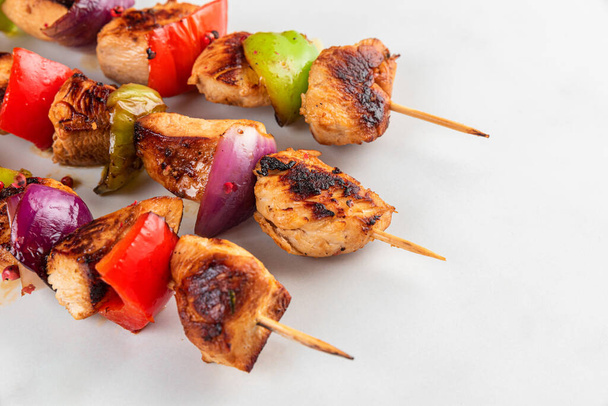 Grilované kuřecí prsní maso grilovací špejle se zeleninou na bílém pozadí. Shish kebab. Zblízka. chutné jídlo - Fotografie, Obrázek