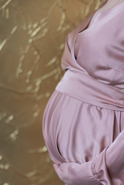 Beautiful caucasian pregnant woman in pink dress. - Фото, изображение