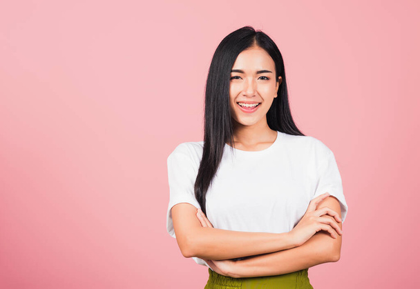 Asian happy portrait beautiful cute young woman standing her smile confidence with crossed arms isolated, studio shot on pink background and copy space, Thai female looking to camera - Φωτογραφία, εικόνα