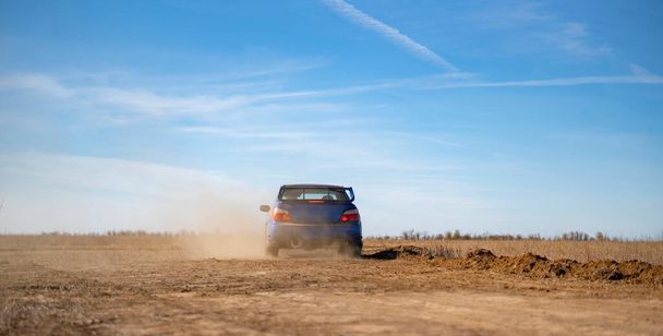 ралійний спортивний автомобіль, що їде на біговій гонці з гравію, швидка швидкість з грязьовими бризками
 - Фото, зображення