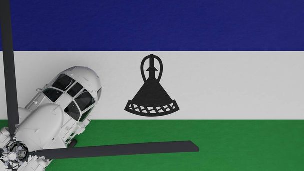 Bovenaanzicht van een witte helikopter in de linkerbenedenhoek en bovenop de nationale vlag van Lesotho - Foto, afbeelding