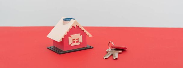 a new small toy house with pair of keys, concept of new apartment purchase flat lay - Photo, Image