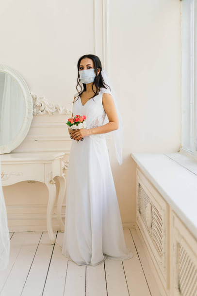 African American bride in dress, mask and in morning preparing for the wedding in hotel room - Φωτογραφία, εικόνα