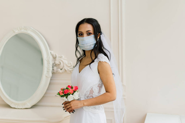 African American bride in dress, mask and in morning preparing for the wedding in hotel room - Photo, Image