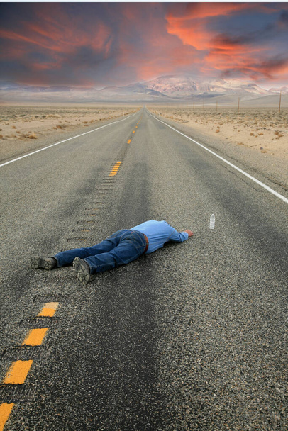 Verdursten. Ein verirrter Wanderer verdurstet auf einer menschenleeren Wüstenstraße, nur wenige Zentimeter von einer Wasserflasche entfernt. Serie Dunkler Humor. verdurstete Person mit einer Flasche Wasser, die gerade außer Reichweite war. Mann verdurstet auf verlassener Autobahn im Death Valley. - Foto, Bild