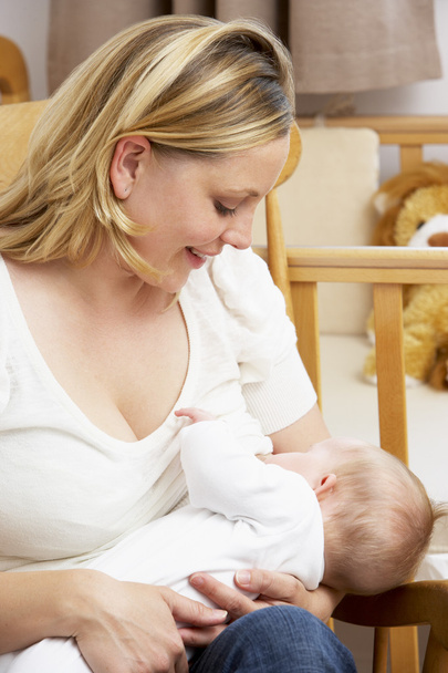 Mother Breastfeeding Baby In Nursery - Foto, Imagen