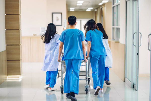 Gruppo di medici professionisti e assistente con stetoscopio in uniforme che porta il paziente gravemente ferito al pronto soccorso in ospedale. - Foto, immagini