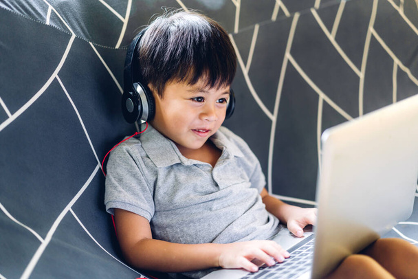 Schulkind kleiner Junge lernen und Blick auf Laptop-Computer Hausaufgaben machen lernen Wissen mit Online-Bildung E-Learning-System.Kinder Videokonferenz mit Lehrer Tutor zu Hause - Foto, Bild