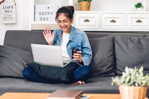 Молода усміхнена азіатська жінка, використовуючи технології ноутбука комп'ютер працює і відеоконференції онлайн зустріч з колегами вдома. Молода творча дівчина розмовляє відеодзвінок з діловою командою. робота з дому
 - Фото, зображення