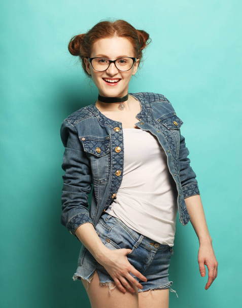 beautiful young red haired woman wearing casual clothes, posing on blue background - Foto, Bild