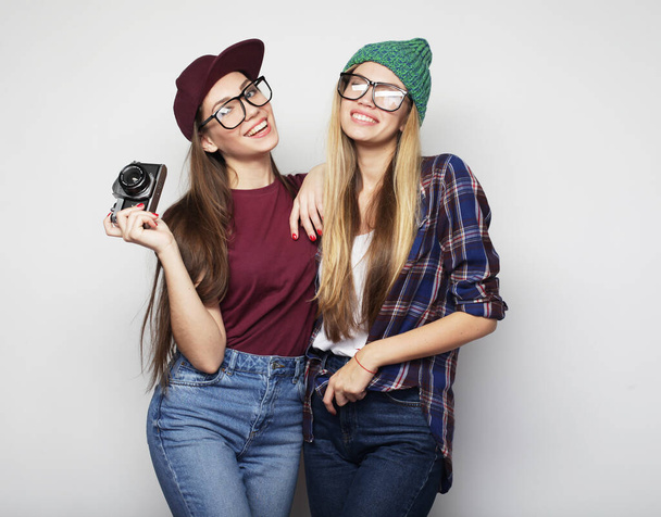 lifestyle, friendship, emotion and people concept: Happy girls friends taking some pictures witn vintage camera - Fotoğraf, Görsel