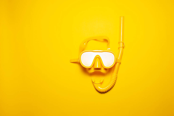Close-up top view καταδυτικού εξοπλισμού με αναπνευστήρα και γυαλιά, σε κίτρινο φόντο. - Φωτογραφία, εικόνα