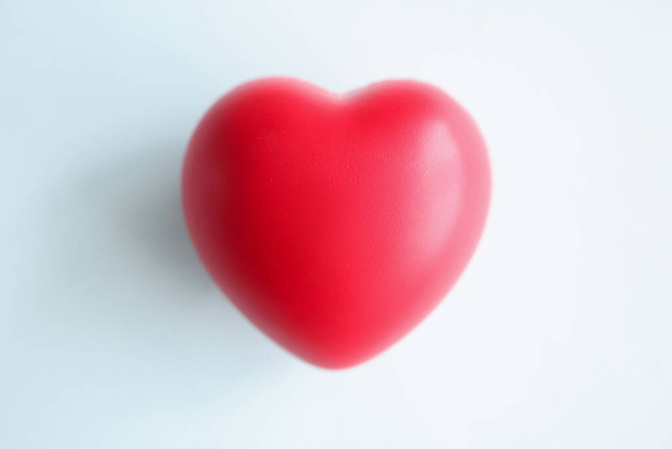 Small red heart on blue blurred background - Fotoğraf, Görsel