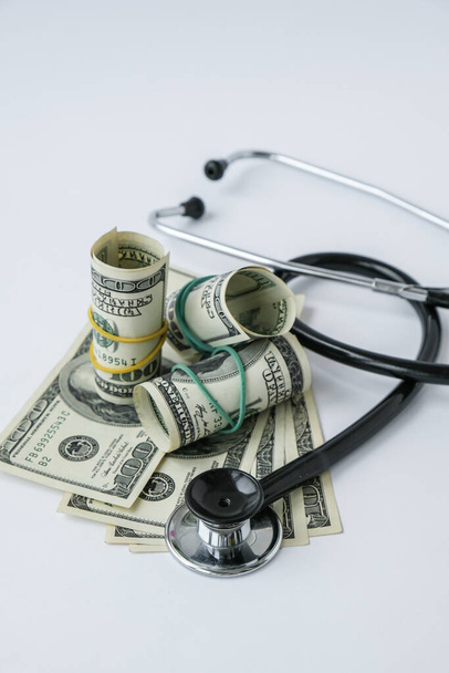 Stack of cash dollars and stethoscope. The concept of medical expensive medicine, doctors salary. Copy space for text. Health Life insurance. vaccination costs. Financial crisis. Covid-19 crimes - Foto, imagen