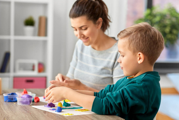 madre e hijo jugando con arcilla de modelado en casa - Foto, imagen
