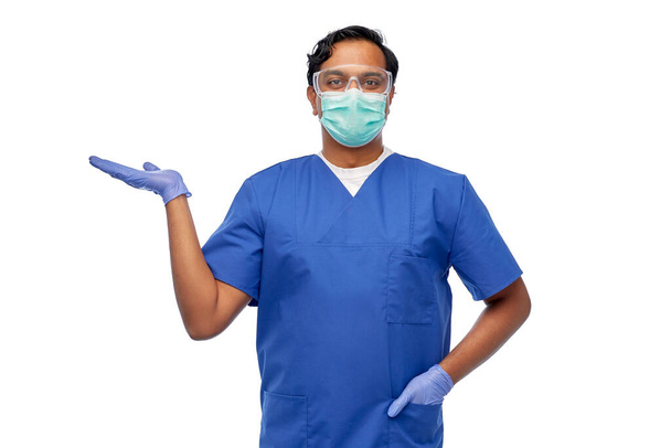 indian male doctor in mask holding something - Valokuva, kuva