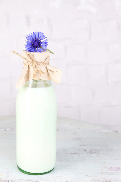 Bottle of milk and cornflowers on wooden table - Фото, изображение