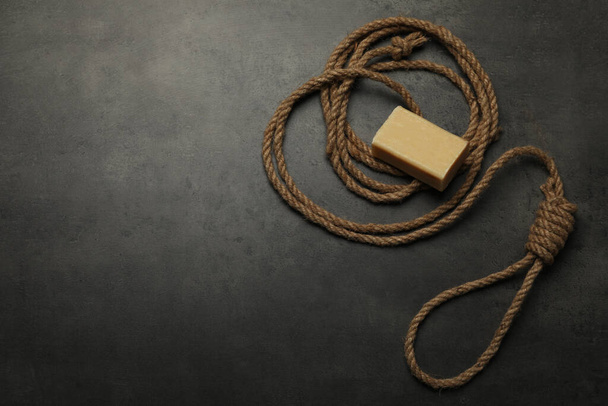Rope noose and soap bar on grey table, flat lay. Space for text - Фото, изображение