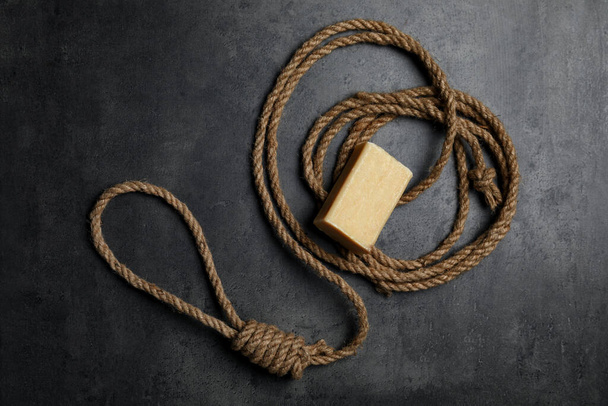 Rope noose and soap bar on grey table, flat lay - Foto, imagen