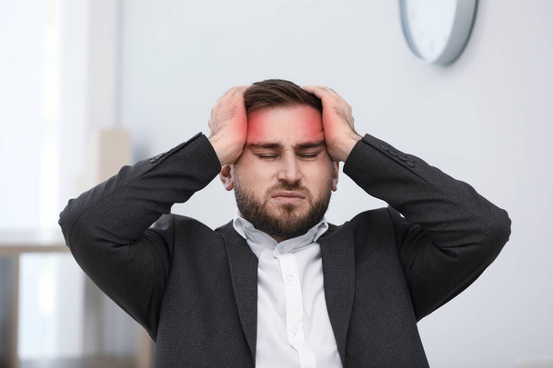 Young man suffering from migraine in office - Zdjęcie, obraz