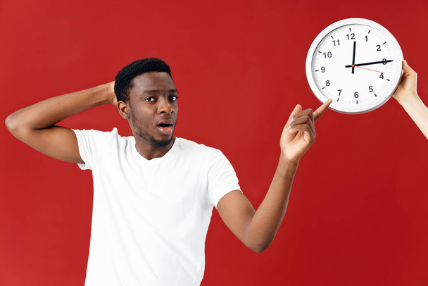 surprised man next to clock in white t-shirt cropped view - 写真・画像