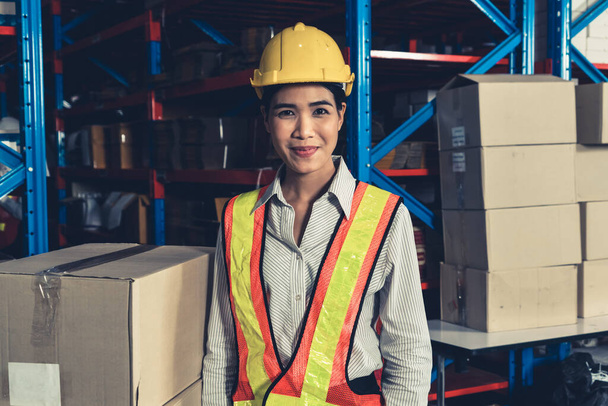 Портрет молодої азіатки працівниці складу посміхається на складі - Фото, зображення