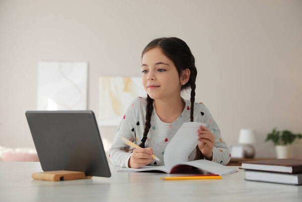 Little girl doing homework with modern tablet at home - Zdjęcie, obraz