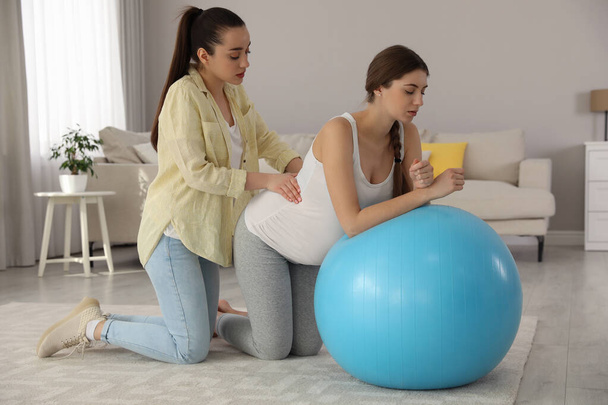 Doula working with pregnant woman in living room. Preparation for child birth - Foto, Bild
