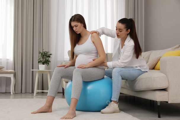 Doula working with pregnant woman in living room. Preparation for child birth - Fotoğraf, Görsel
