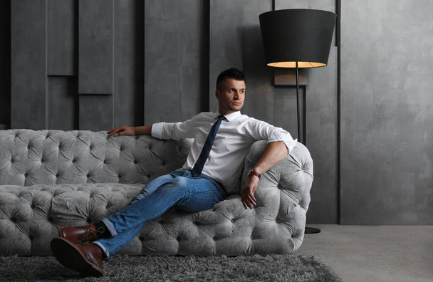 Schöner Geschäftsmann auf dem Sofa drinnen. Luxus-Lebensstil - Foto, Bild
