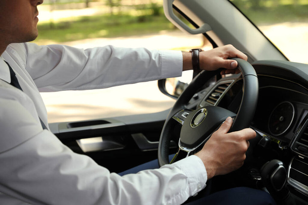 Man driving his car, closeup view of hands on steering wheel - Φωτογραφία, εικόνα
