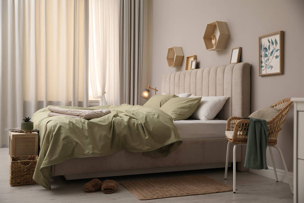 Nagy kényelmes ágy, gyönyörű ágyneművel a szobában - Fotó, kép