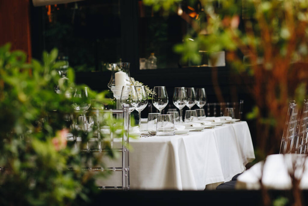 tableware Glasses, flower fork, knife served for dinner in restaurant with cozy interior - Foto, Bild