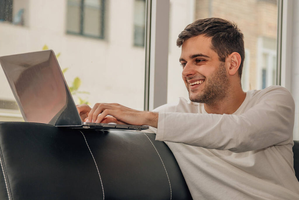 jeune homme barbu travaillant avec ordinateur portable à la maison - Photo, image