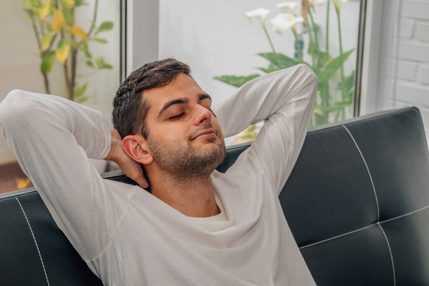 muž odpočívající uvolněně na pohovce doma - Fotografie, Obrázek