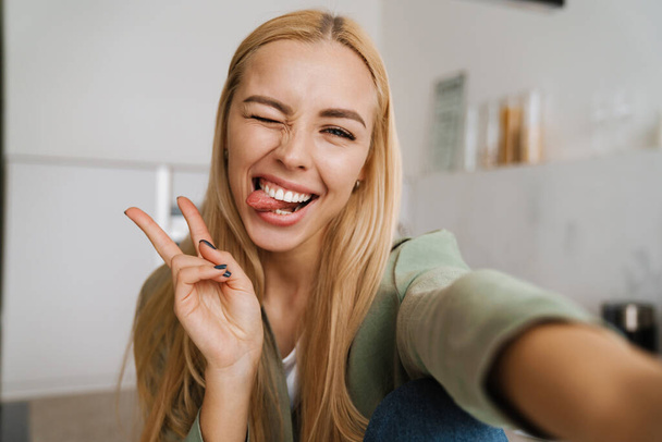 Close up portrait of a smiling pretty woman making a selfie indoors - Φωτογραφία, εικόνα