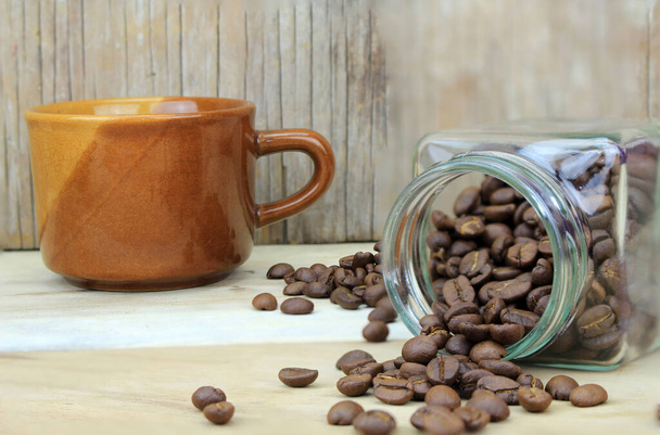 Bir fincan kahve ve kahve şişesinde fasulye. - Fotoğraf, Görsel