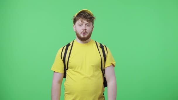Portrait of young men looking at camera with excitement, then celebrating victory triumph. Male in yellow delivery courier uniform posing on green screen. Close up. Slow motion ready 59.97fps. - Video