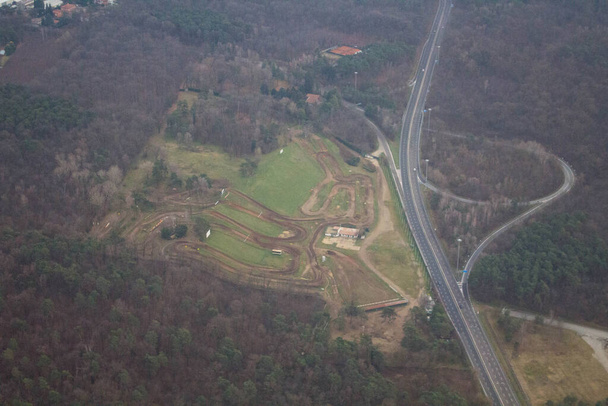 20.12.27 Aeropuerto de Milán Malpensa, vista del panorama después del despegue con un campo de motocross en el fondo - Foto, imagen