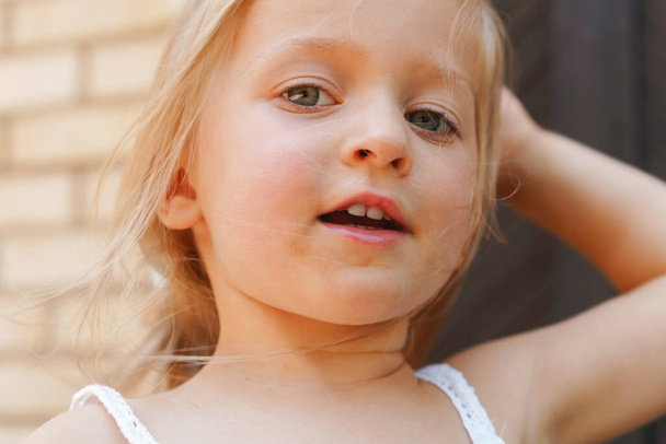 Close up portrait of a little blonde girl on a summer day - Photo, Image