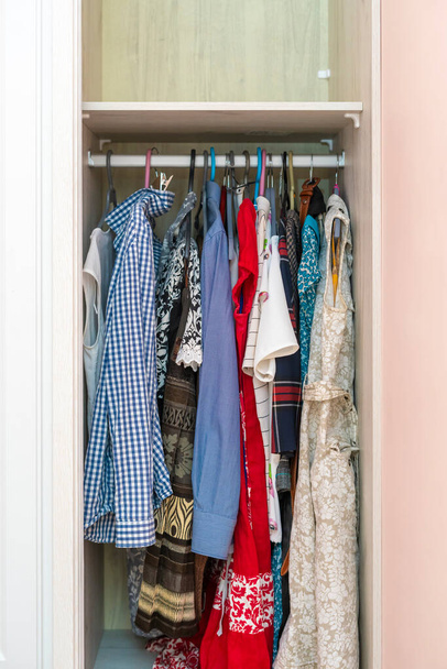 un armario de casa con algunas perchas y ropa - Foto, imagen