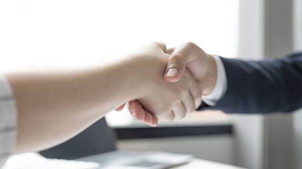 Business personage handshake, Ασιάτισσες επιχειρηματίες συγχαίρουν για την εταιρική σχέση με τους ευρωπαίους άνδρες επενδυτές, Φιλίας, Χαιρετισμούς στη νοηματική γλώσσα, Επιτυχημένες επιχειρηματικές διαπραγματεύσεις. - Φωτογραφία, εικόνα