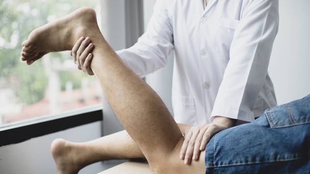 Physiothérapie, Physiothérapeute féminine traite les douleurs aux jambes et aux hanches pour un patient masculin fréquentant une clinique, Arrangement osseux, Traitement médical non chirurgical, Techniques médicales modernes. - Photo, image