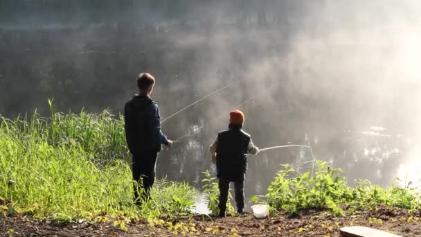 красивое место на озере утренний туман детей рыбалка с удочками - Кадры, видео