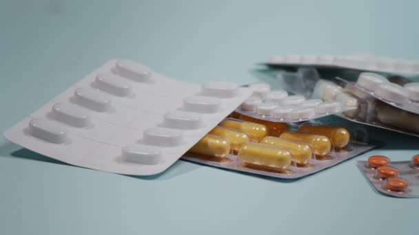 Supplementen en pillen blisterverpakkingen geïsoleerd op blauwe achtergrond, close-up. - Video