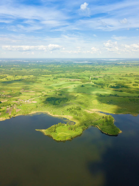 Schöne Landschaft an den Braslaver Seen von einer Drohne an einem sonnigen Tag mit wolkenverhangenem Himmel, Weißrussland. Vertikales Foto. Halbinsel in Form eines Stiefels - Foto, Bild