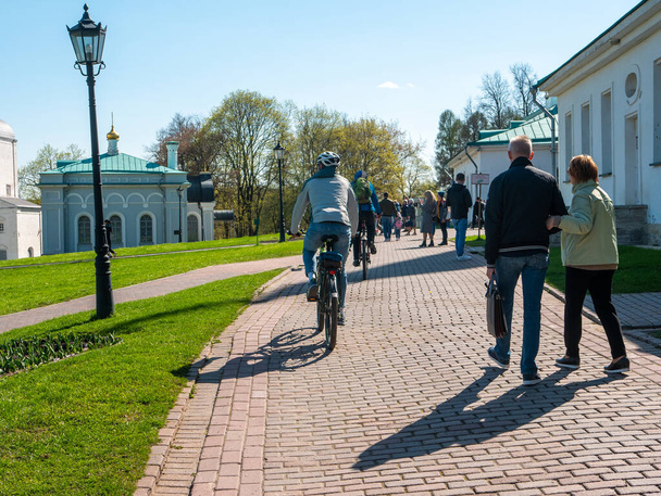 Moscú, Rusia - 1 de mayo de 2021: Brillante día soleado de primavera en el parque Kolomenskoye, Moscú. Las familias caminan y montan bicicletas en un gran parque y disfrutan del buen tiempo en un día de mayo. - Foto, imagen