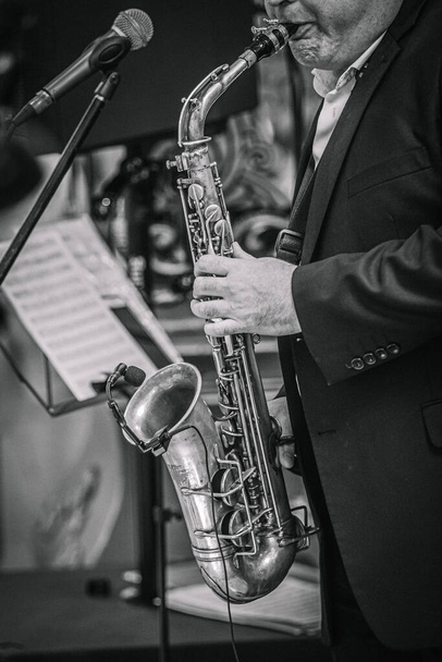 un saxofonista toca música en un evento en un café. - Foto, Imagen